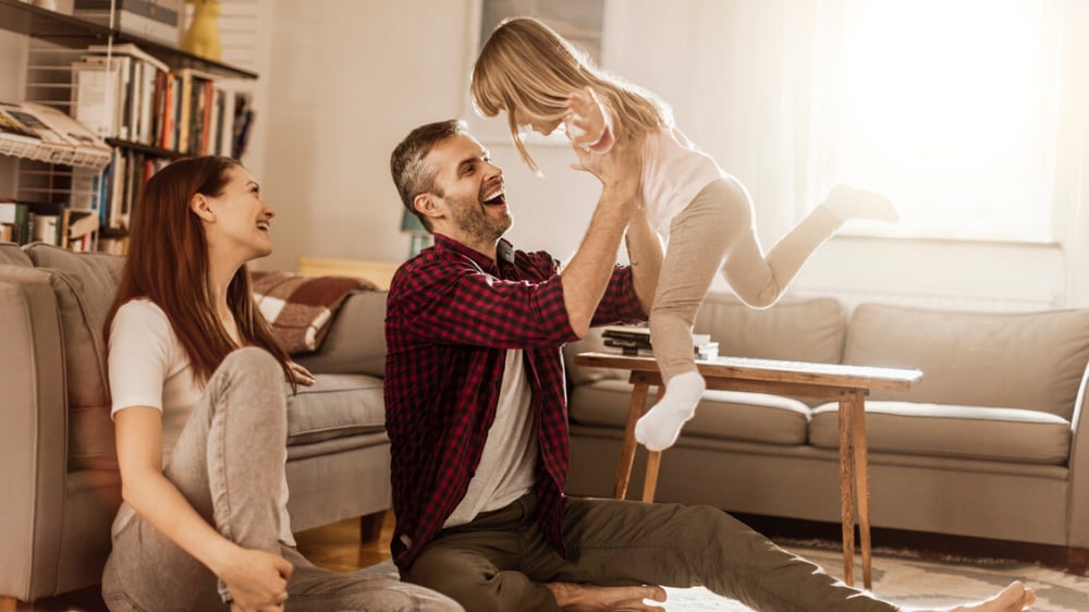 A young family having a laugh in their living room