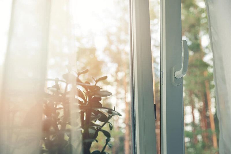 Open window of cottage with view on forest